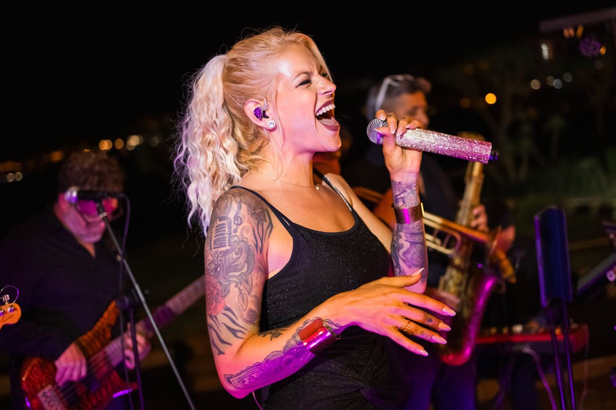 Cantante de Glitter Funk actuando en directo con la banda durante un evento nocturno